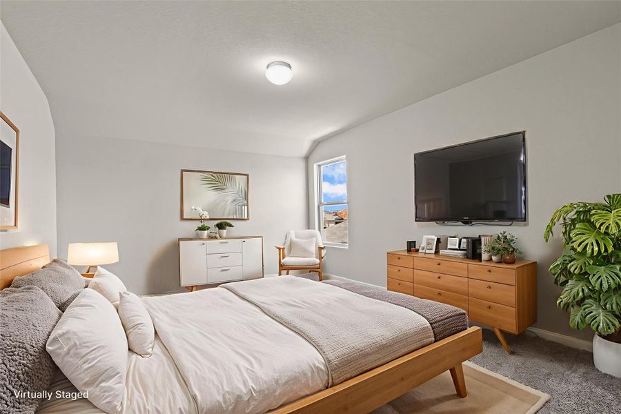A well-lit bedroom provides comfort and serenity, featuring sloped ceilings and ample space.
