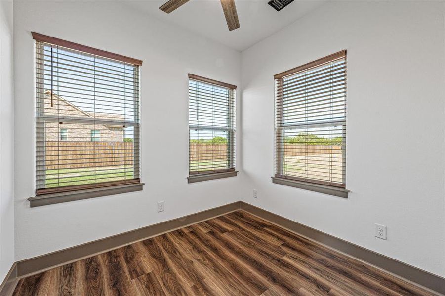 Unfurnished room featuring dark wood-style floors and a ceiling fan
