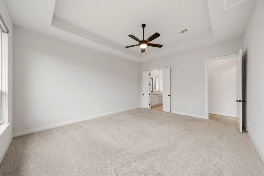 Double doors open to the primary bath, creating a grand entrance and a distinct sense of privacy while setting the tone for the spa-inspired space beyond.