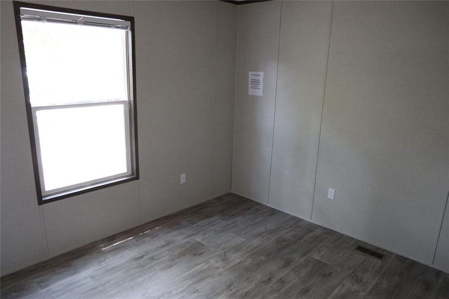 Unfurnished room featuring wood-type flooring and a wealth of natural light