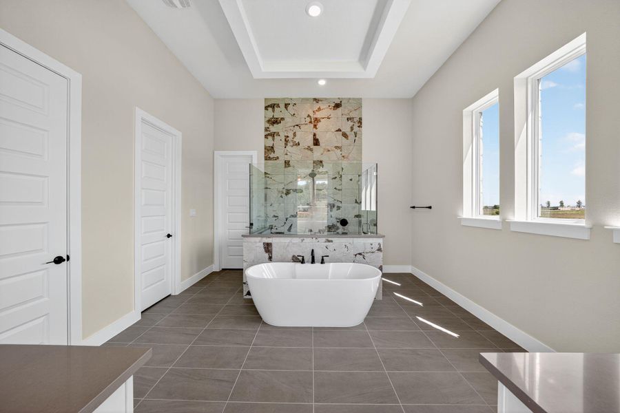 Full bath with a marble finish shower, tile patterned flooring, a soaking tub, a raised ceiling, and recessed lighting Full bath with a marble finish shower, tile patterned flooring, a soaking tub, a raised ceiling, and recessed lighting
