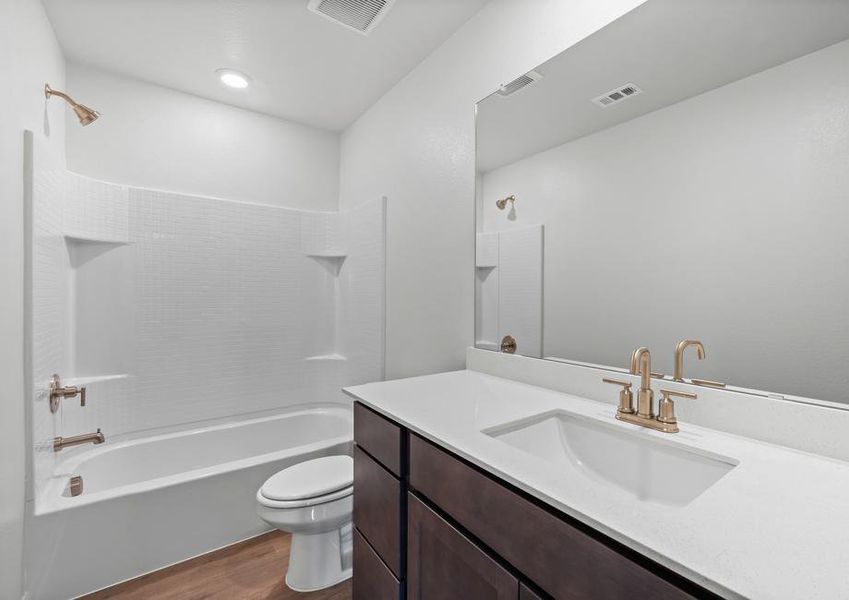 The secondary bathroom has a large vanity space and a shower-tub combo.