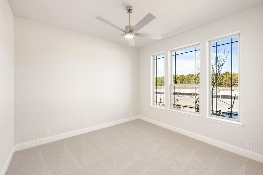 Empty bedroom with carpet flooring, ceiling fan, and three windows with outdoor views Empty bedroom with carpet flooring, ceiling fan, and three windows with outdoor views