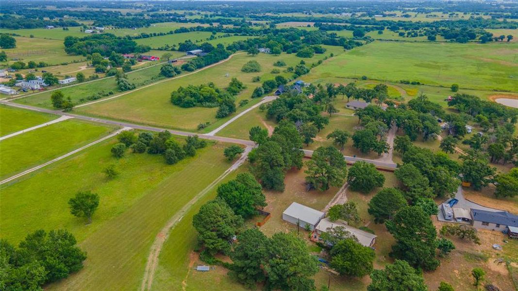 Aerial view highlighting the home's acreage, mature trees, workshop, and peaceful rural setting. Aerial view highlighting the home's acreage, mature trees, workshop, and peaceful rural setting.
