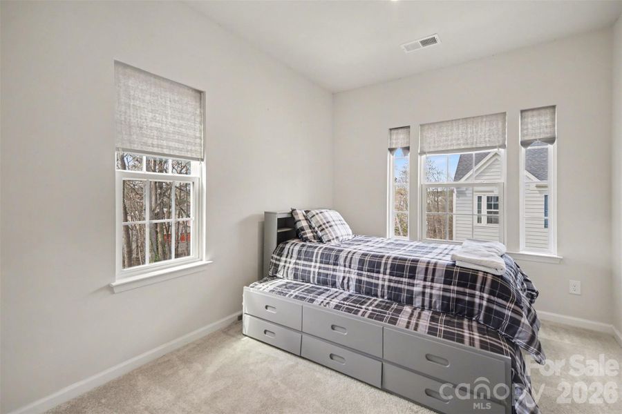 Spacious secondary bedroom with multiple windows and walk-in closet