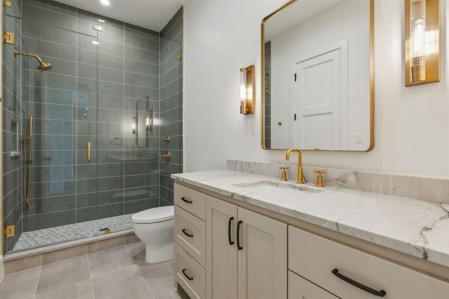 Bathroom with tile patterned floors, vanity, a shower with shower door, and toilet