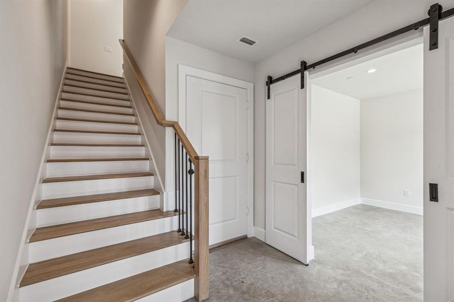 Study on 1st floor with barn door, concrete floors and recessed lighting