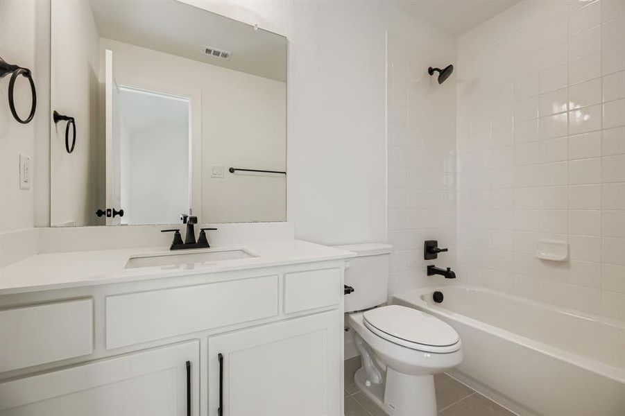 Bathroom featuring vanity, shower / bathtub combination, and light tile patterned floors Bathroom featuring vanity, shower / bathtub combination, and light tile patterned floors