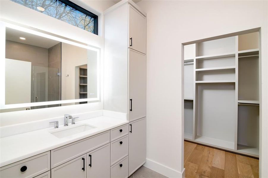 Bathroom with hardwood / wood-style floors, vanity, and walk in shower