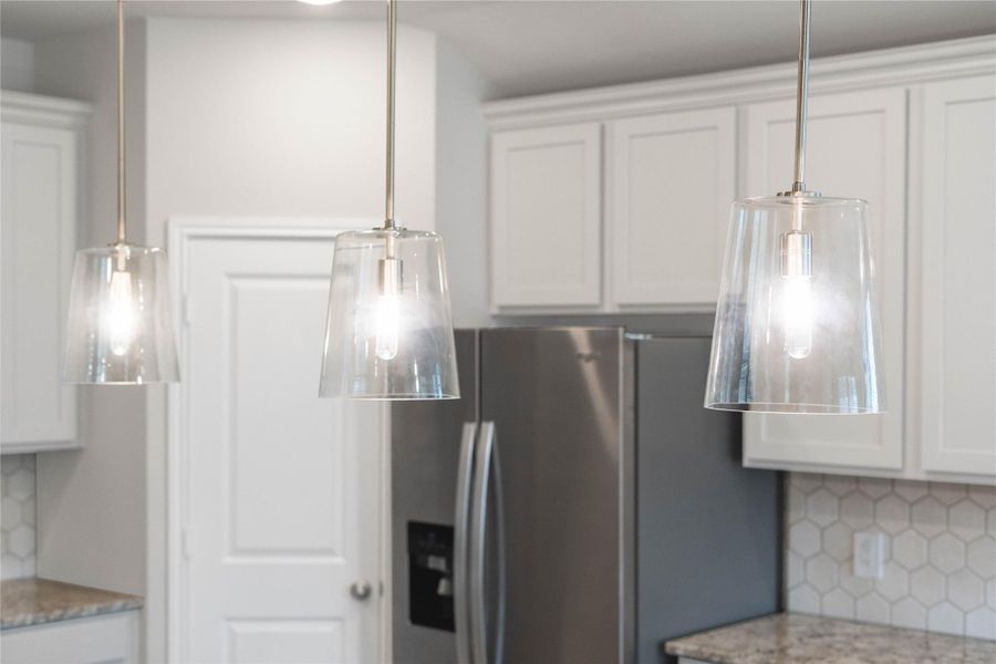 Clarion Pendants Brushed Nickel pendant lights that hang over the kitchen island.