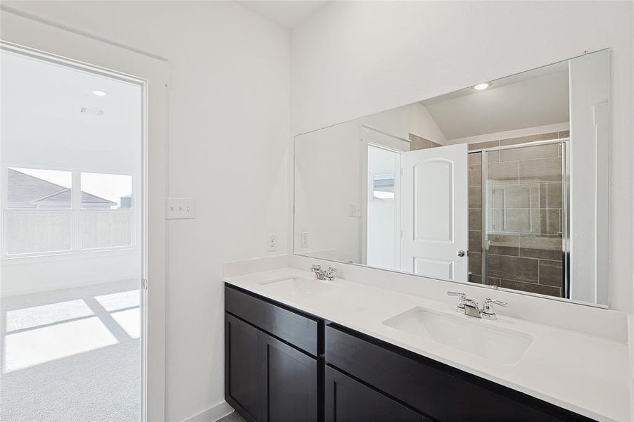 Bathroom with vanity, an enclosed shower, and lofted ceiling