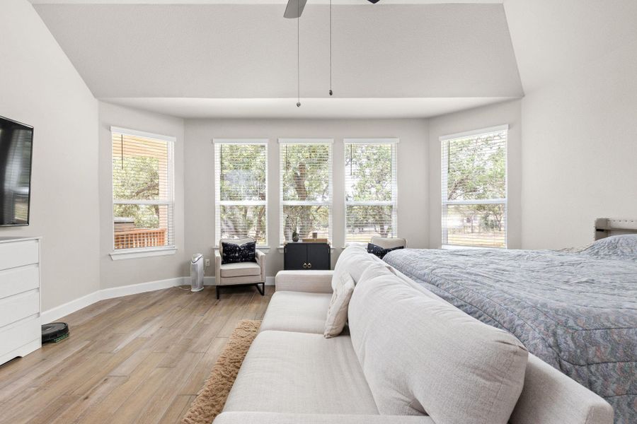 Primary suite featuring light brown tile floors and ceiling fan