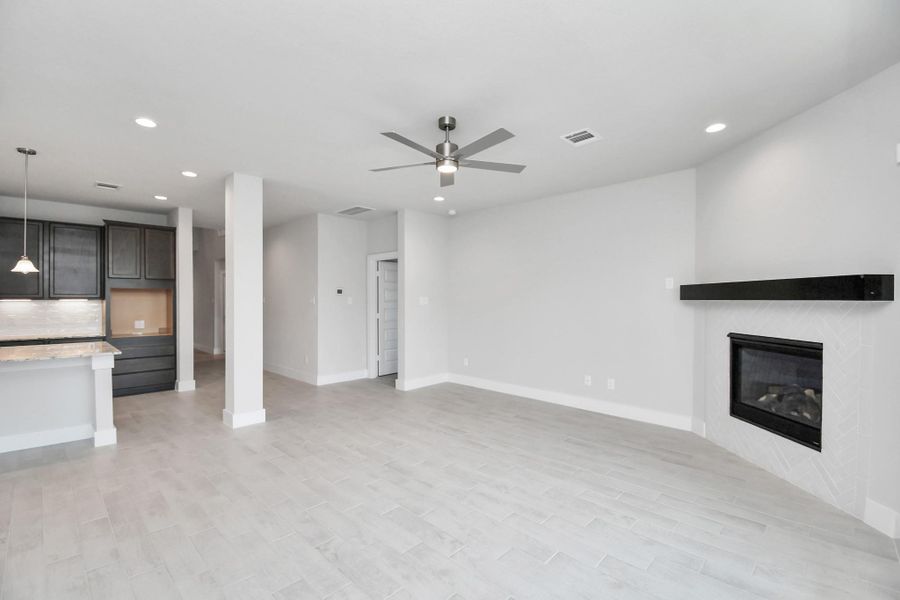 Welcome family and guests to your charming living room! With its high ceilings, recessed lighting, ceiling fan, custom paint, beautiful flooring, and a large window that lets in abundant natural light, this room is perfect for gatherings. Welcome family and guests to your charming living room! With its high ceilings, recessed lighting, ceiling fan, custom paint, beautiful flooring, and a large window that lets in abundant natural light, this room is perfect for gatherings.