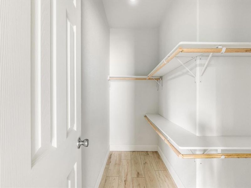 Walk in closet featuring light wood-style flooring Walk in closet featuring light wood-style flooring