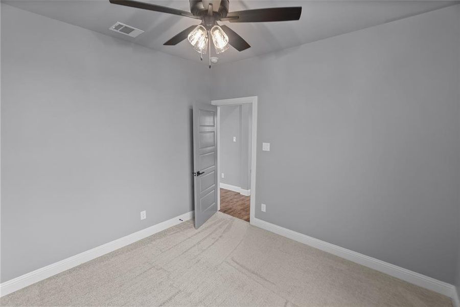 Carpeted empty room featuring ceiling fan