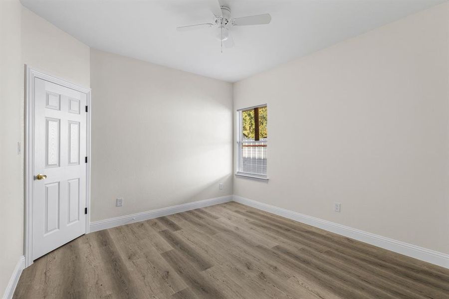 Empty room with ceiling fan and wood-type flooring