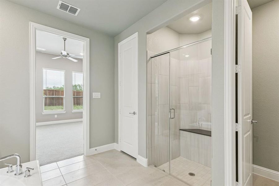 Full bath with a stall shower, tile patterned floors, and a ceiling fan