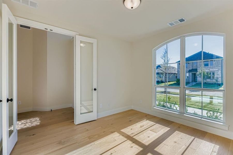 Unfurnished room with light wood finished floors and french doors
