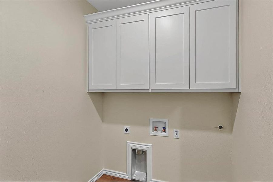 Laundry area featuring cabinet space, electric dryer hookup, baseboards, and washer hookup Laundry area featuring cabinet space, electric dryer hookup, baseboards, and washer hookup