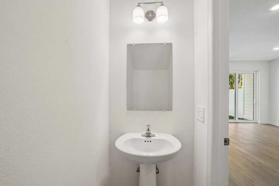 Half bathroom located off the kitchen on the first floor Half bathroom located off the kitchen on the first floor