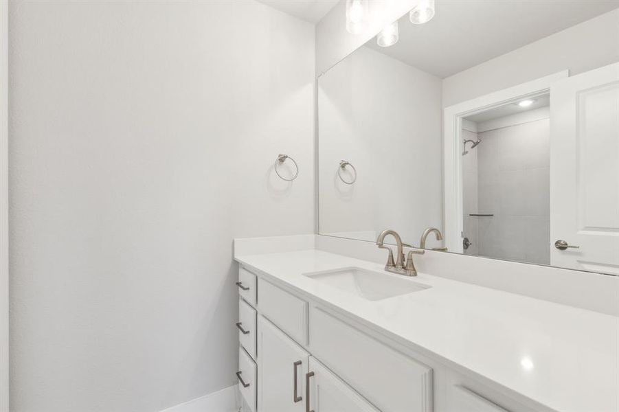 Bathroom featuring vanity and a shower Bathroom featuring vanity and a shower