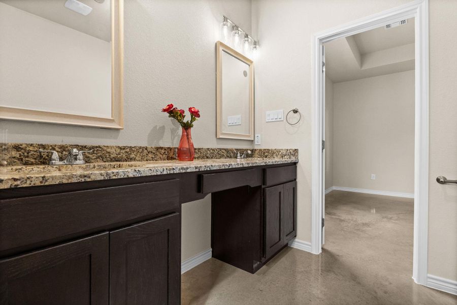 Full bathroom featuring double vanity and finished concrete flooring