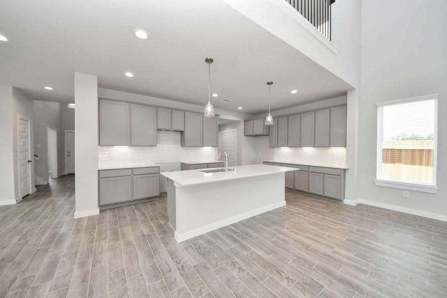 This generously spacious kitchen is a dream realized! With a massive granite island, high ceilings, soft close cabinets, granite countertops, stainless steel appliances, a sleek tile backsplash, recessed lighting, and an extended counter area, it offers both style and practicality. Sample photo of completed home with similar floor plan. Actual colors and selections may vary. This generously spacious kitchen is a dream realized! With a massive granite island, high ceilings, soft close cabinets, granite countertops, stainless steel appliances, a sleek tile backsplash, recessed lighting, and an extended counter area, it offers both style and practicality. Sample photo of completed home with similar floor plan. Actual colors and selections may vary.