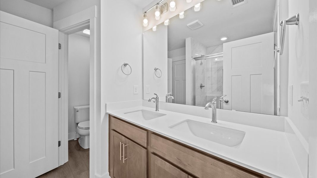 Double sink vanity with white quartz countertops in two story townhome at Ransdell Pointe by DRB Homes in Spartanburg, SC
