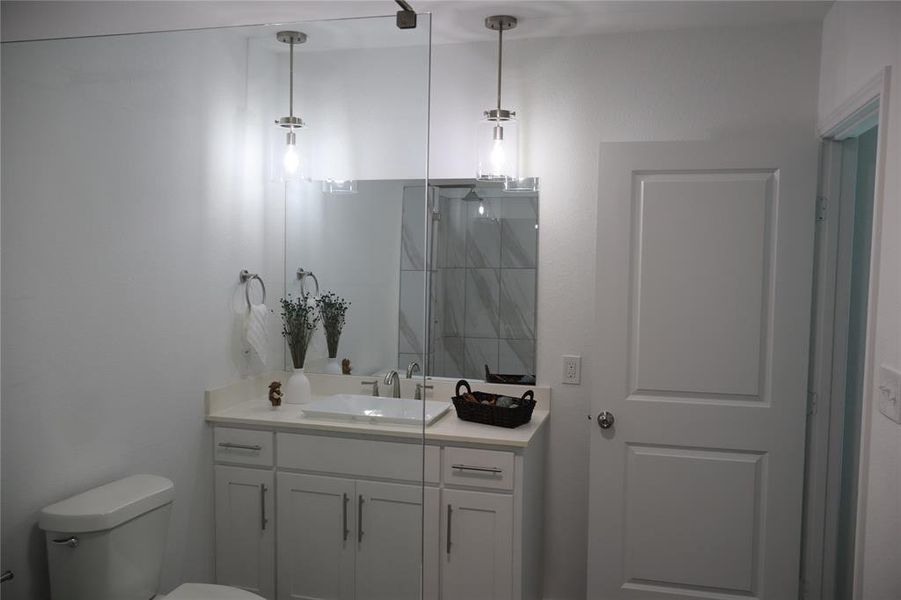 Bathroom featuring a white vanity with an undermount sink, a light-toned countertop, and chrome fixtures