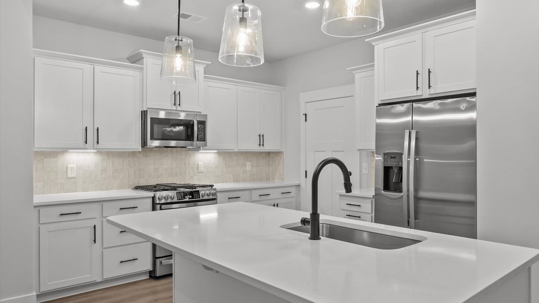 Superior kitchen with quartz countertops, pendant lighting, and a generously sized island Superior kitchen with quartz countertops, pendant lighting, and a generously sized island