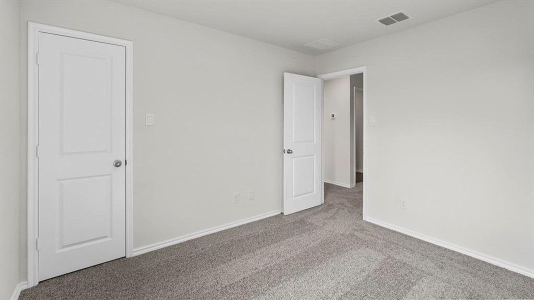 The room features light gray walls, white baseboards, and gray carpet