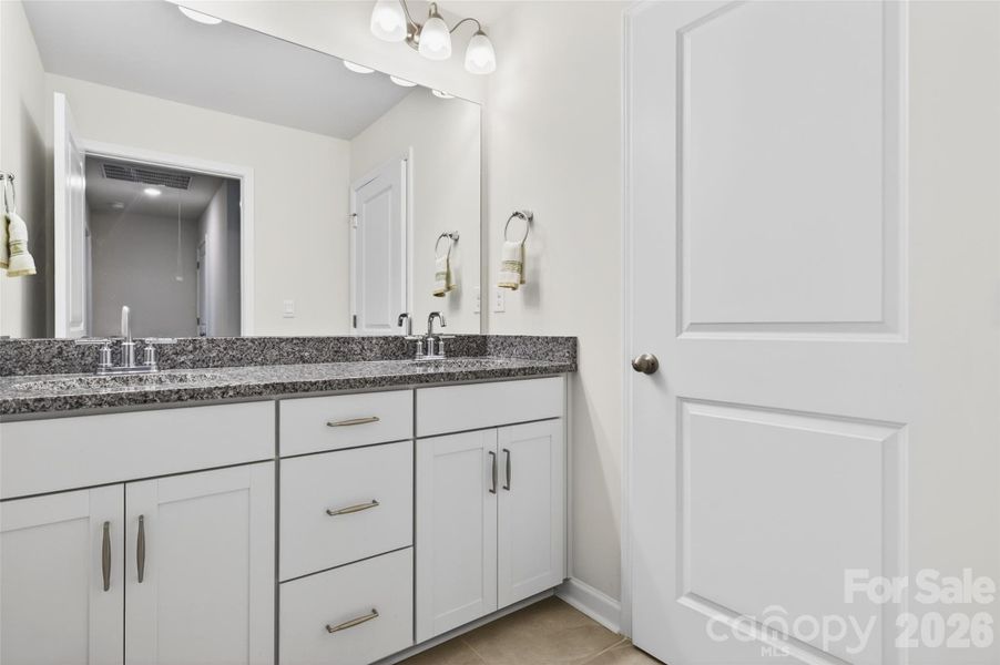 Shared full bath on upper level with dual sinks.