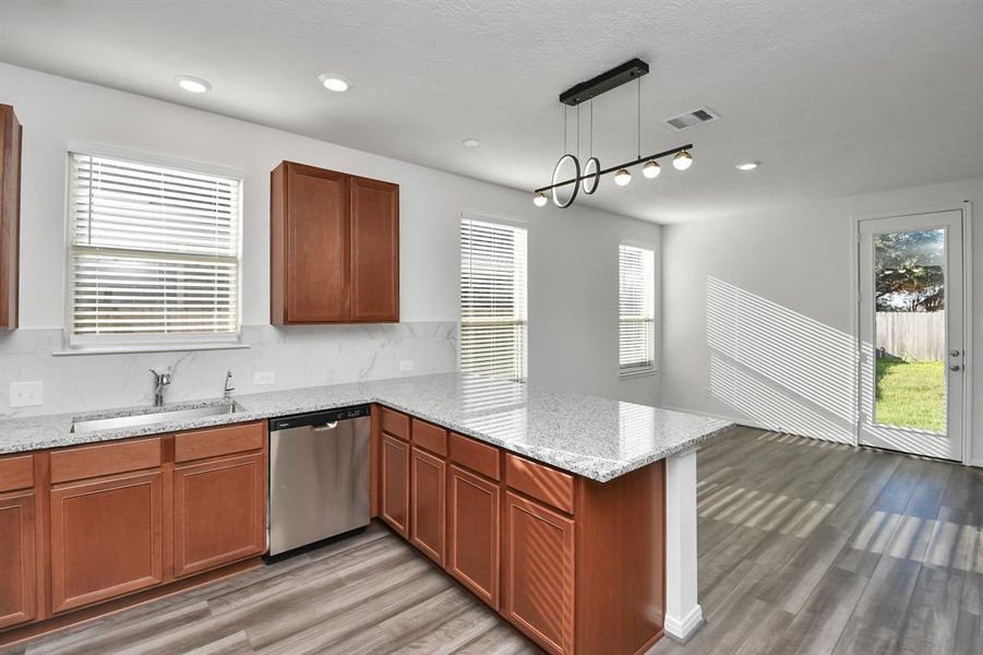 Stylish Island kitchen boasts granite counters,farm sink,stainless appliances, 42”cabinets,large walk-in pantry and open living concept.