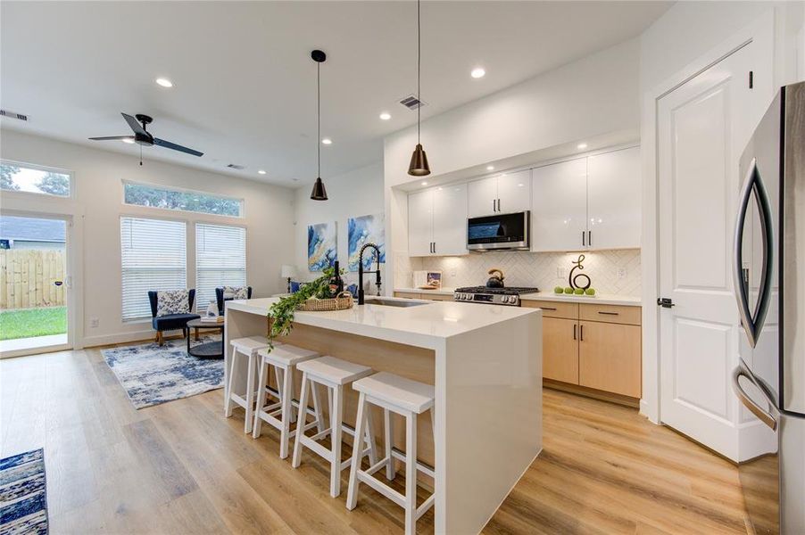 This luxurious kitchen comes with smart appliances, white quartz waterfall counters, modern European style soft-close cabinetry, walk-in pantry, and more! Fridge included!