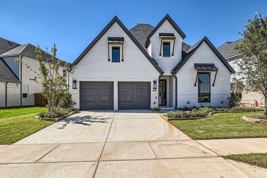 View of front of house featuring a front yard and a garage