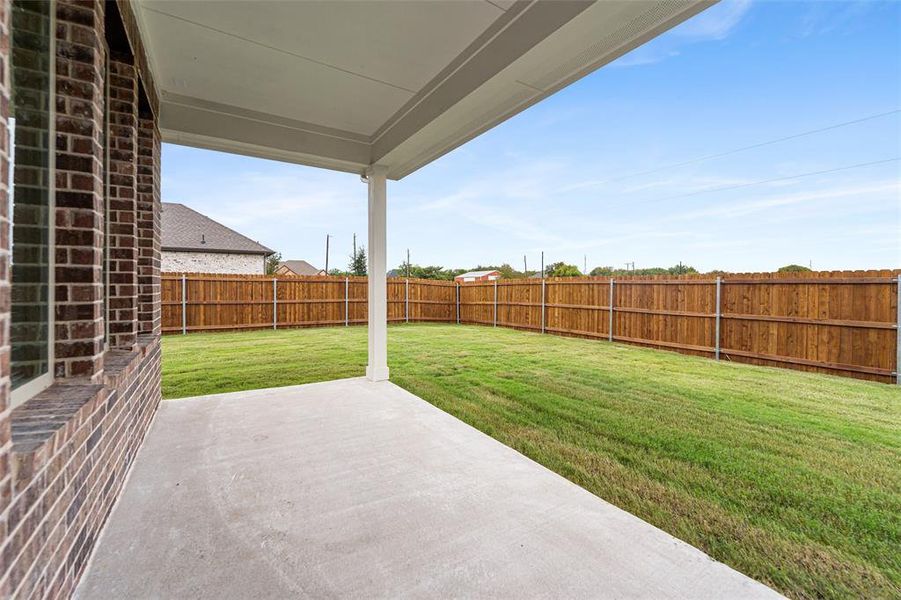 Fenced backyard with a patio area Fenced backyard with a patio area