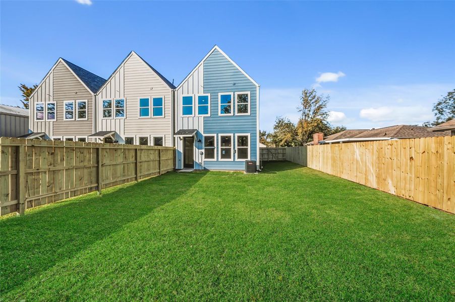 Spacious fenced backyard and vibrant blue and beige exterior. Ideal for privacy and outdoor activities.