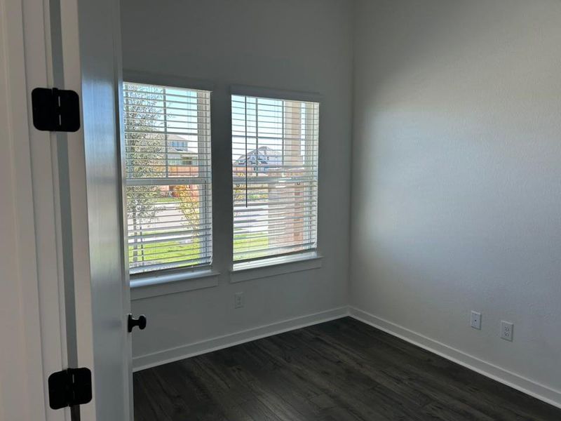 Spare room with baseboards and dark wood-type flooring Spare room with baseboards and dark wood-type flooring