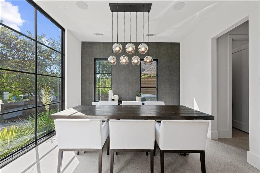 Dining space featuring floor to ceiling windows and a chandelier