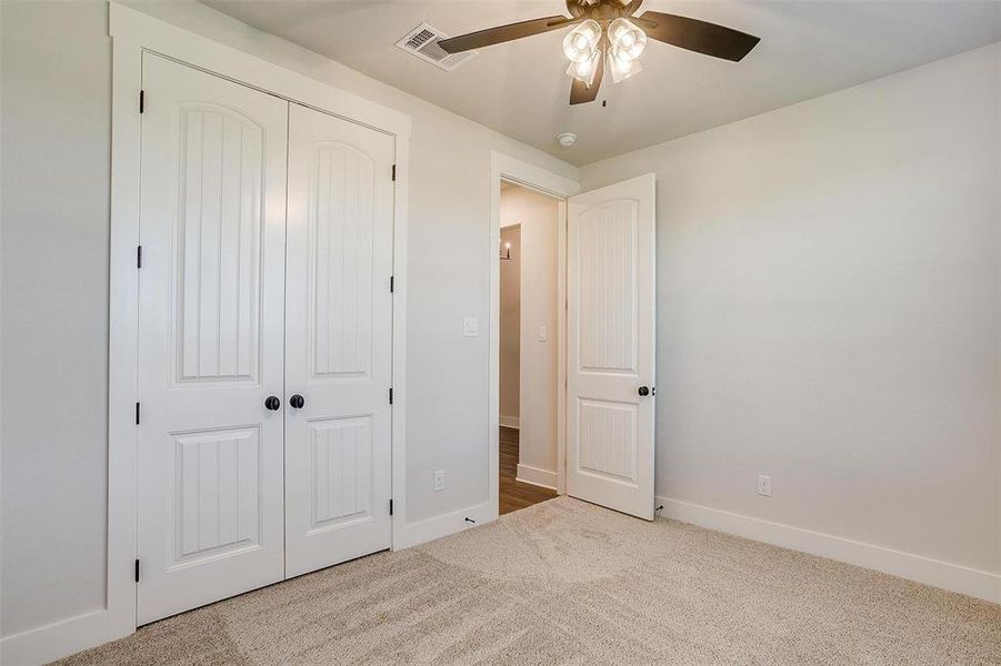 Unfurnished bedroom with carpet, a closet, and ceiling fan