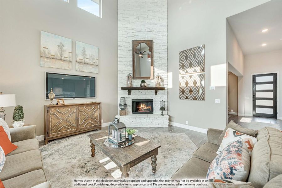 Living room with two-story white stone fireplace, high ceilings, and neutral furniture