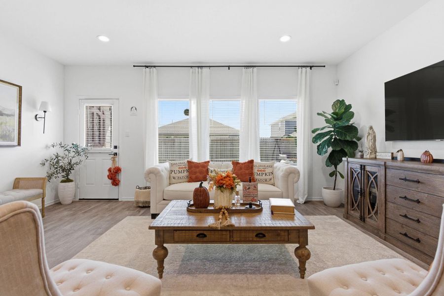 Bright open-concept living area with abundant natural light and warm vinyl wood flooring. Bright open-concept living area with abundant natural light and warm vinyl wood flooring.
