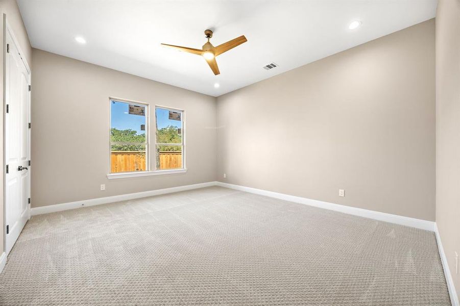 Carpeted room featuring ceiling fan