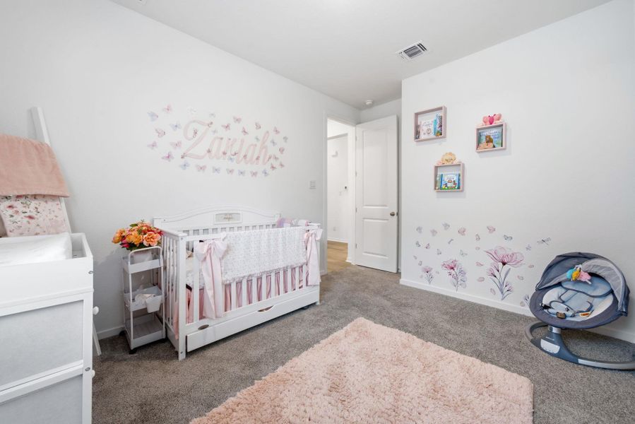Bedroom with a nursery area and dark carpet