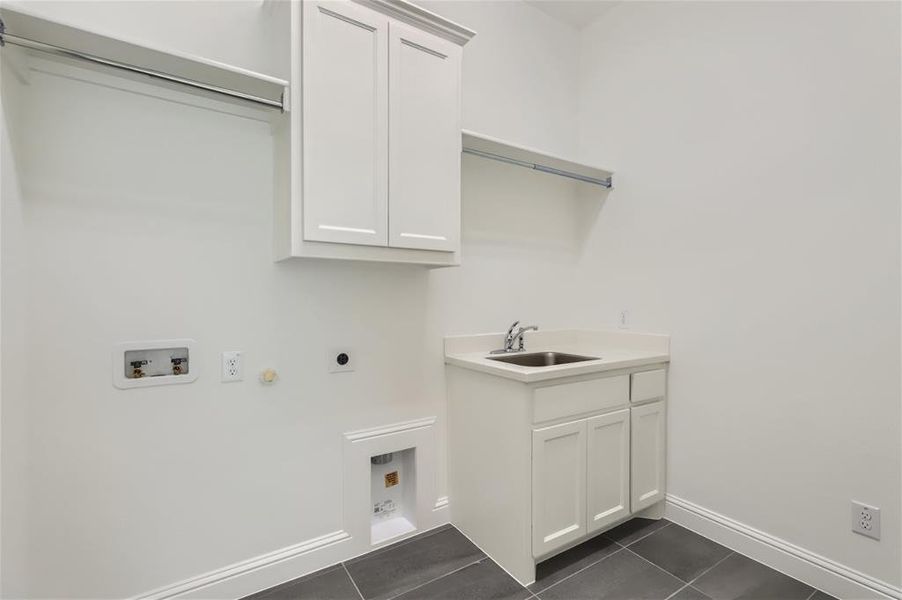 Laundry area featuring washer hookup, gas dryer hookup, electric dryer hookup, sink, and dark tile flooring