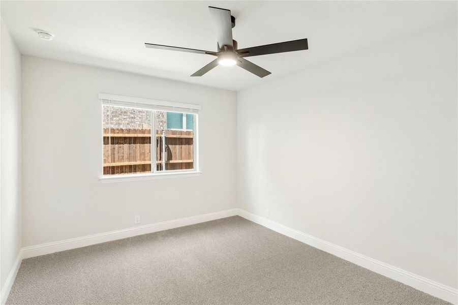 Empty bedroom with gray carpet, white walls, ceiling fan with light, and single window Empty bedroom with gray carpet, white walls, ceiling fan with light, and single window