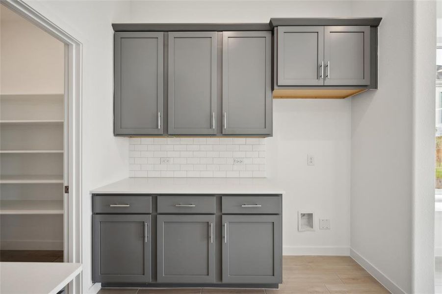 Kitchen featuring backsplash, light wood-type flooring, and gray cabinets