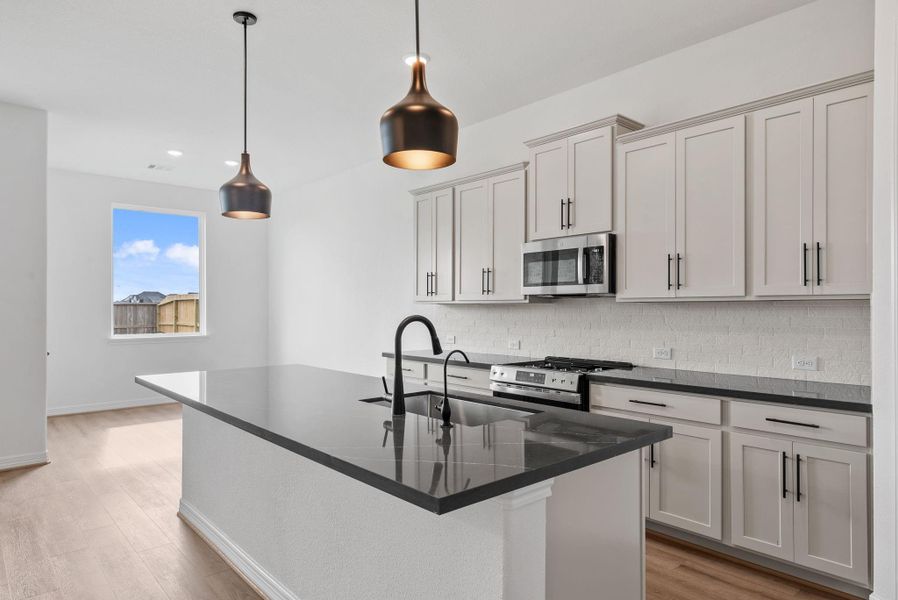 Kitchen flows effortlessly into the dining and living rooms, creating a bright and social gathering space.