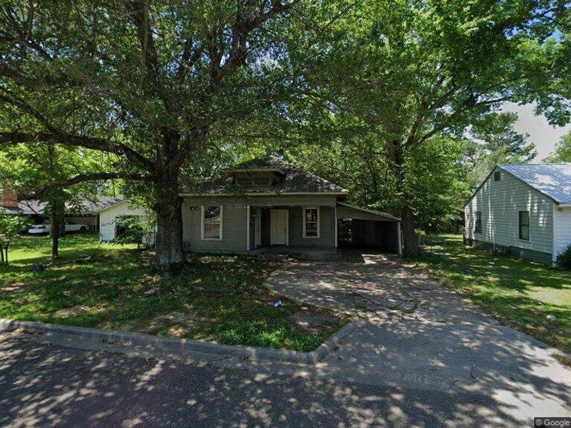 Bungalow-style house featuring asphalt driveway, a carport, a front lawn, and a patio