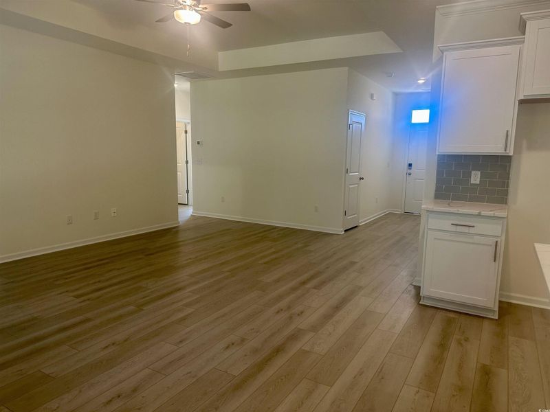 Unfurnished living room featuring light wood-type flooring and ceiling fan